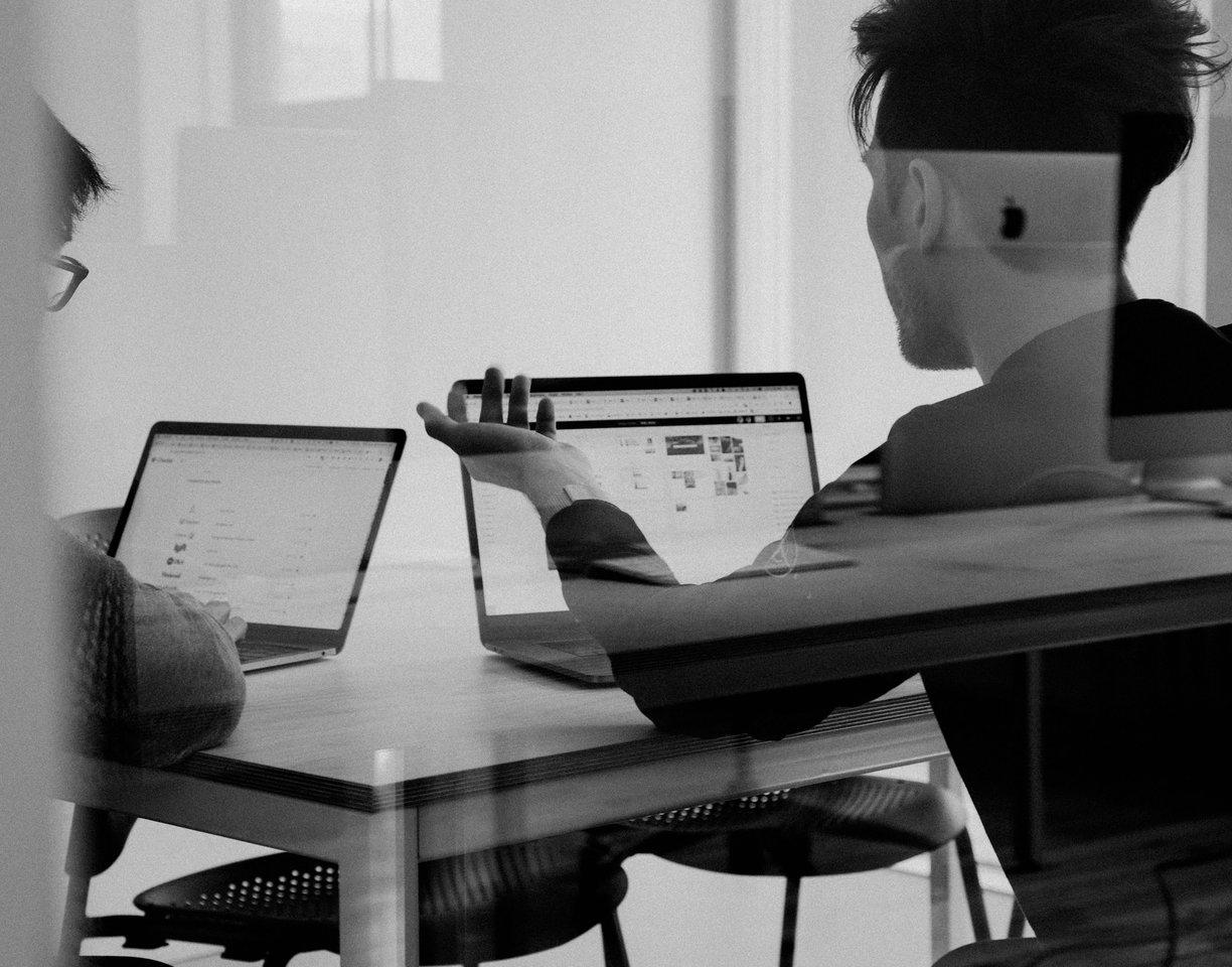 Una scrivania di studio con portatili e schermi, dove si fa il lavoro
