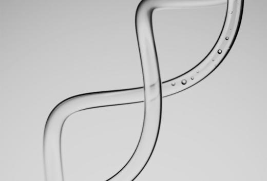 A clear glass tube curving in an S shape against a pale grey background