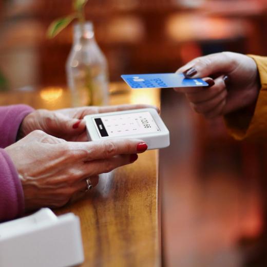A customer paying by card at a contactless reader