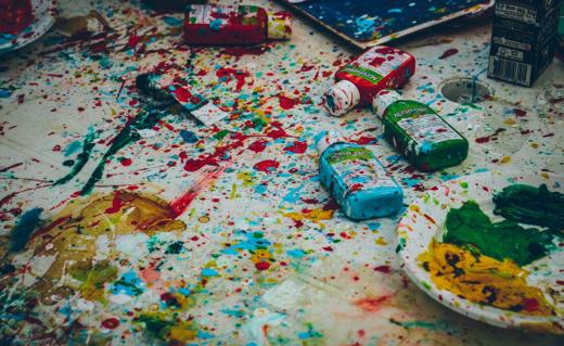 Spilled paint and brushes across a studio floor