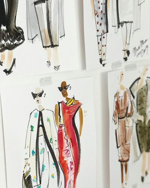 Ilustraciones de moda clavadas en la pared de un estudio