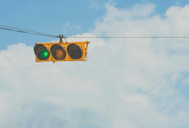 A traffic light showing green against an open sky